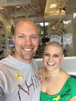 Wes and Nicole standing smiling after they have their heads shaved prior to Nicole losing her hair through chemo.