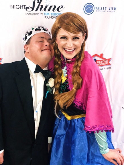 Nicole dressed up as Anna from Frozen volunteering at Night to Shine with one of the honored guests.