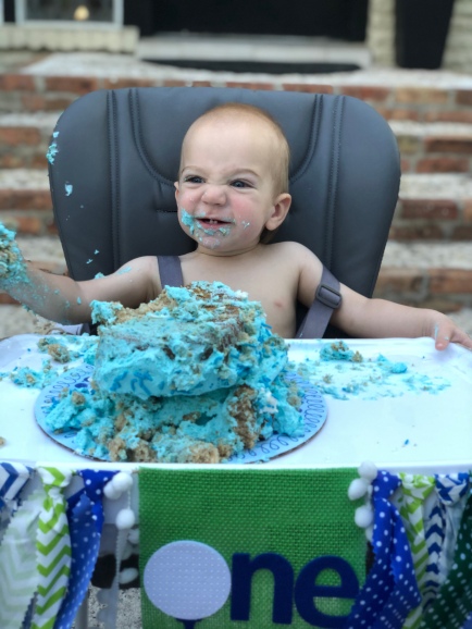 Our nephew, Easton, smashing his first birthday cake at his 1st birthday party covered in blue frosting.